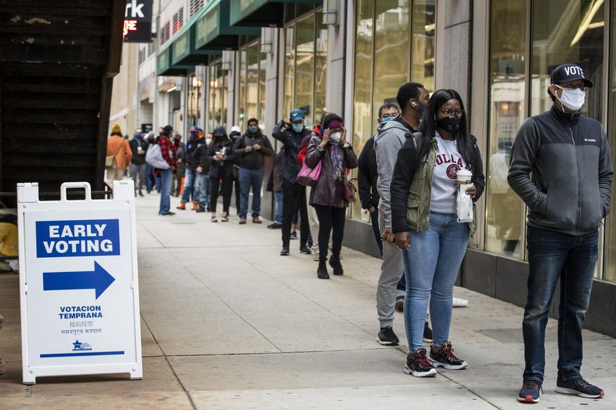 Hundreds of people wait in line to early vote at the Loop Super Site, Thursday morning, Oct. 1, 2020, in Chicago. Voters on Thursday say they understand the fears of contracting the deadly coronavirus has prompted millions of Americans to vote by mail. But they are worried about the “chaos and confusion” that President Donald Trump has created about mail-in voting and they say they want to vote in person to make sure those votes are counted. (Ashlee Rezin Garcia/Chicago Sun-Times via AP)