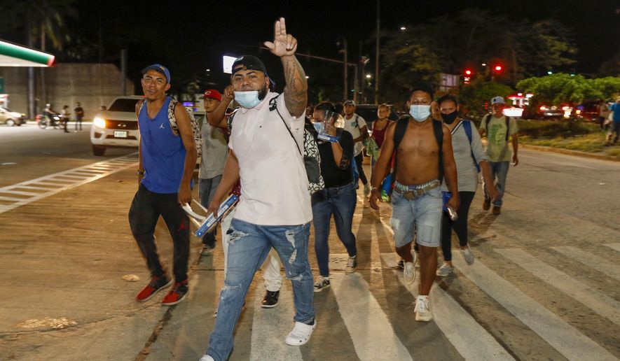 Migrants walk along a highway in hopes of reaching the distant United States, in San Pedro Sula, Honduras, Wednesday, Sept. 30, 2020. Hundreds of migrants have begun walking from this northern Honduras city toward the Guatemala border testing a well-trod migration route now in times of the new coronavirus. (AP Photo)