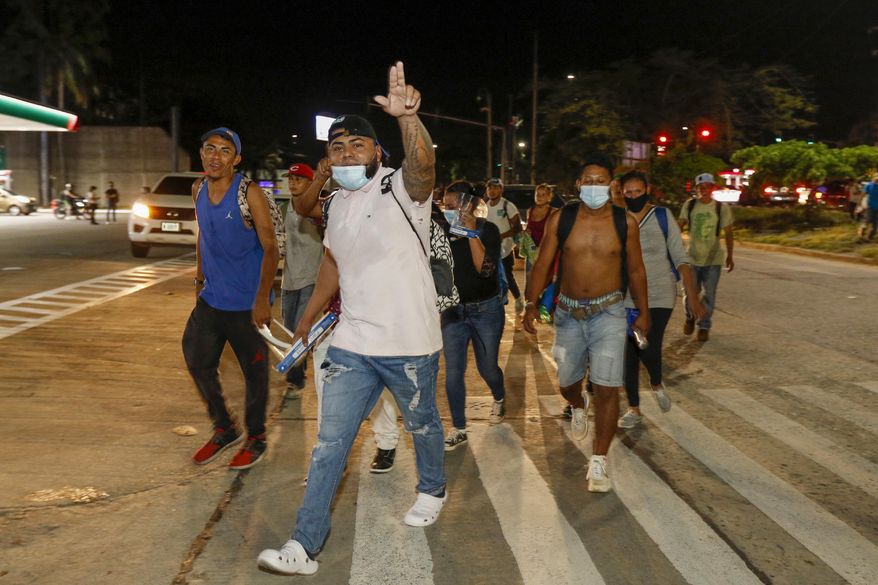 Migrants walk along a highway in hopes of reaching the distant United States, in San Pedro Sula, Honduras, Wednesday, Sept. 30, 2020. Hundreds of migrants have begun walking from this northern Honduras city toward the Guatemala border testing a well-trod migration route now in times of the new coronavirus. (AP Photo)