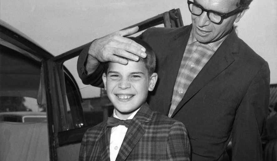FILE - In this July 2, 1961, file photo, Dave Brubeck, the American Jazz musician, and his 13-year-old son Christopher, also a musician, arrive at London Airport, United Kingdom, from New York. Nearly eight years after his death, the final solo recording of late American jazz legend Dave Brubeck is set for release Nov. 6, 2020. Verve Records announced that "Lullabies," a collection of intimate standards often played for children, will be available in the latest effort by a label to preserve unreleased jazz recordings. (AP Photo/Brian Calvert, File)