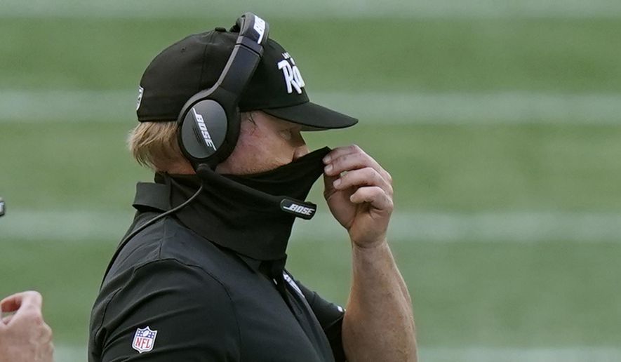Las Vegas Raiders head coach Jon Gruden adjusts his protective mask along the sideline in the second half of an NFL football game against the New England Patriots, Sunday, Sept. 27, 2020, in Foxborough, Mass. (AP Photo/Steven Senne) **FILE**