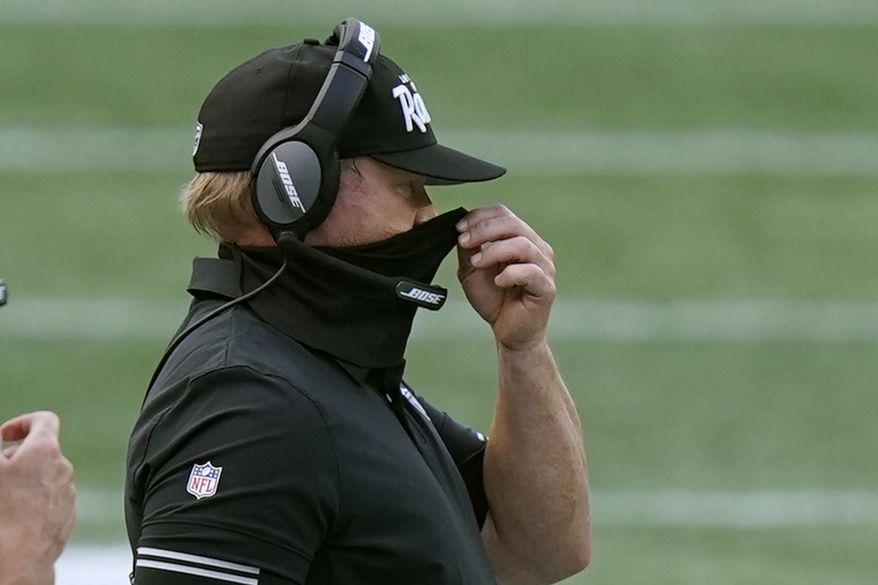 Las Vegas Raiders head coach Jon Gruden adjusts his protective mask along the sideline in the second half of an NFL football game against the New England Patriots, Sunday, Sept. 27, 2020, in Foxborough, Mass. (AP Photo/Steven Senne) **FILE**