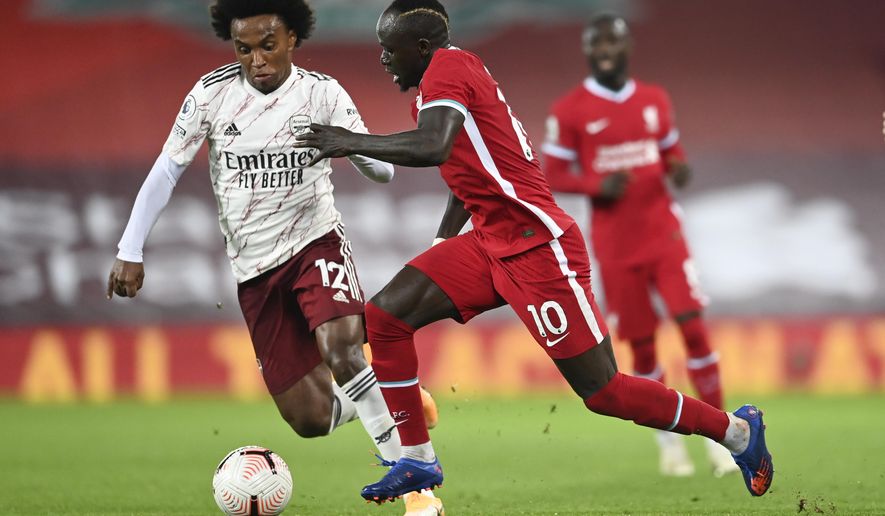 Liverpool's Sadio Mane, right, takes the ball past Arsenal's Willian during the English Premier League soccer match between Liverpool and Arsenal at Anfield in Liverpool, England, Monday, Sept. 28, 2020. (Laurence Griffiths/Pool via AP)