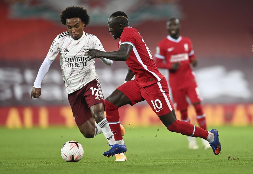 Liverpool's Sadio Mane, right, takes the ball past Arsenal's Willian during the English Premier League soccer match between Liverpool and Arsenal at Anfield in Liverpool, England, Monday, Sept. 28, 2020. (Laurence Griffiths/Pool via AP)