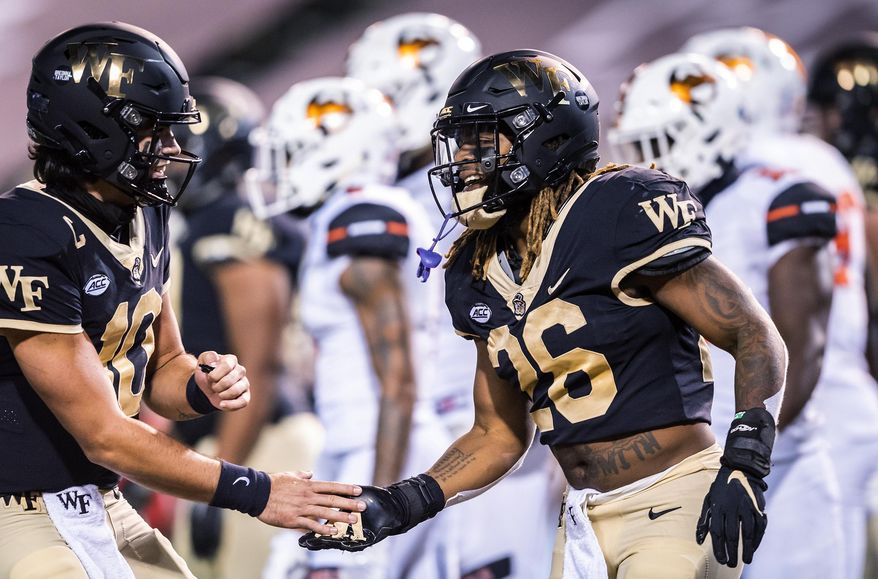 Wake Forest running back Christian Beal-Smith (26) celebrates his touchdown with quarterback Sam Hartman (10) during an NCAA college football game against Campbell on Friday, Oct. 2, 2020, in Winston-Salem, N.C. (Andrew Dye/The Winston-Salem Journal via AP)