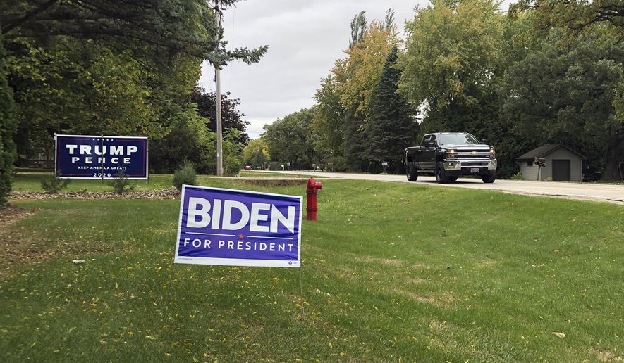Signs for Democratic presidential candidate former Vice President Joe Biden and President Donald Trump mark neighboring property in a middle-class neighborhood of Oshkosh, the hub of swing-voting Winnebago County Wis.  (AP Photo/Thomas Beaumont)  **FILE**
