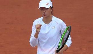 Poland&#39;s Iga Swiatek clenches her fist after scoring a point against Canada&#39;s Eugenie Bouchard in the third round match of the French Open tennis tournament at the Roland Garros stadium in Paris, France, Friday, Oct. 2, 2020. (AP Photo/Michel Euler)