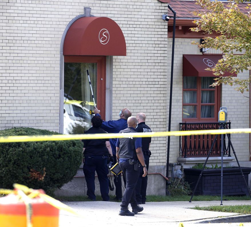 Evidence is gathered after reports of a shooting at Serenity Funeral Home Wednesday, Sept. 30, 2020 in Milwaukee. Several people have been shot and wounded in an apparent drive-by shooting outside the funeral home, but all are expected to survive. Acting Police Chief Michael Brunson said all of the injured are expected to survive and were in stable condition Wednesday at a local hospital. (Rick Wood /Milwaukee Journal-Sentinel via AP)