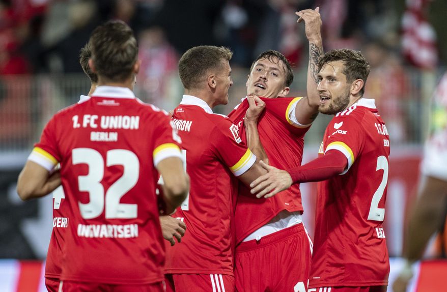 Union's Max Kruse, second right, reacts with teammates after scoring, during the German Bundesliga soccer match between FC Union Berlin and FSV Mainz, at the Stadion An der Alten Forsterei, in Berlin, Friday, Oct. 2, 2020. (Andreas Gora/dpa via AP)