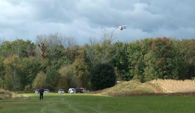 In this photo provided by Spectrum News Buffalo, a helicopter circles the site of a small plane crash near Pembroke N.Y., Friday, Oct. 2, 2020. Two people aboard the aircraft died. (Spectrum News Buffalo via AP)