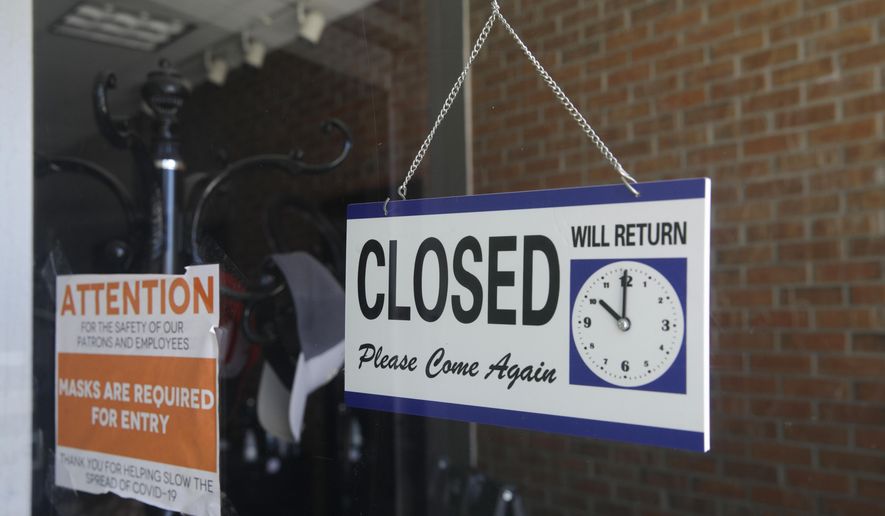 In this July 18, 2020, file photo, a closed sign hangs in the window of a barbershop in Burbank, Calif. (AP Photo/Marcio Jose Sanchez, File)