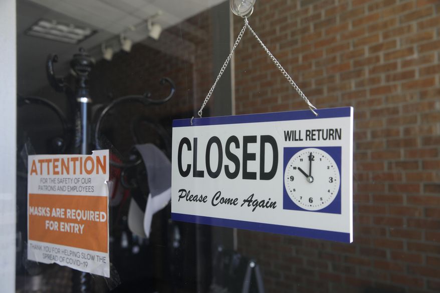 In this July 18, 2020, file photo, a closed sign hangs in the window of a barbershop in Burbank, Calif. (AP Photo/Marcio Jose Sanchez, File)