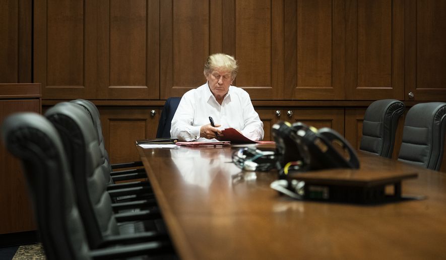 In this image released by the White House, President Donald Trump works in his conference room at Walter Reed National Military Medical Center in Bethesda, Md., Saturday, Oct. 3, 2020, after testing positive for COVID-19. (Joyce N. Boghosian/The White House via AP)