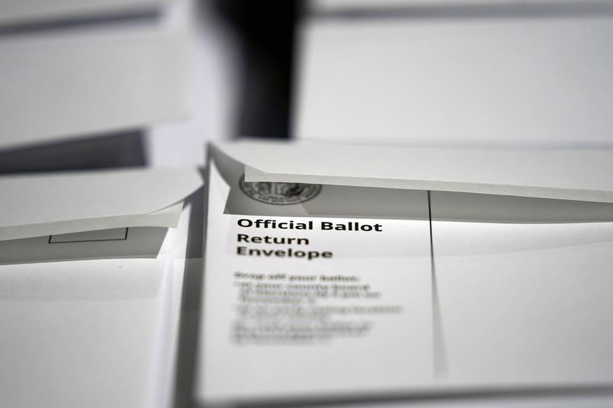FILE - In this Thursday, Sept. 3, 2020, file photo, stacks of ballot envelopes waiting to be mailed are seen at the Wake County Board of Elections in Raleigh, N.C. A federal judge has blocked updated North Carolina absentee voting rules that gave voters more leeway to fix witness problems and extended the period when elections boards could accept mailed-in ballots. U.S. District Judge James Dever issued a temporary retraining order on Saturday, Oct. 3 that blocked the updated rules that resulted from a legal settlement with voting rights advocates. (AP Photo/Gerry Broome, File)