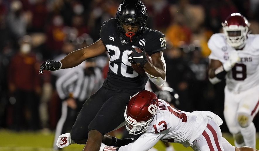 Iowa State running back Breece Hall (28) breaks a tackle by Oklahoma defensive back Tre Norwood (13) during the first half an NCAA college football game, Saturday, Oct. 3, 2020, in Ames, Iowa. (AP Photo/Charlie Neibergall)