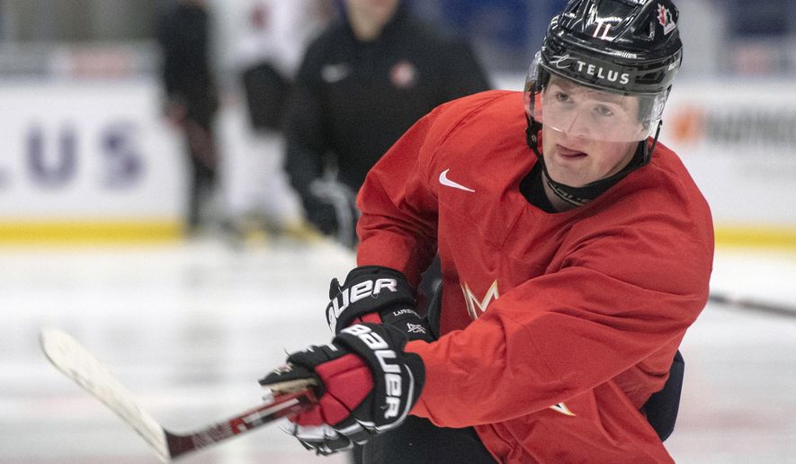 In this Jan. 1, 2020, file photo, Canada's Alexis Lafreniere shoots during the team's practice at the World Junior Hockey Championships in Ostrava, Czech Republic. The New York Rangers might be on the clock in owning the No. 1 pick in the NHL draft on Tuesday, Oct. 6. That, and the prospect of selecting Quebec star forward Alexis Lafreniere, doesn't mean the still-retooling Rangers will be anywhere closer to being a contender, team president John Davidson cautions. (Ryan Remiorz/The Canadian Press via AP, File) **FILE**