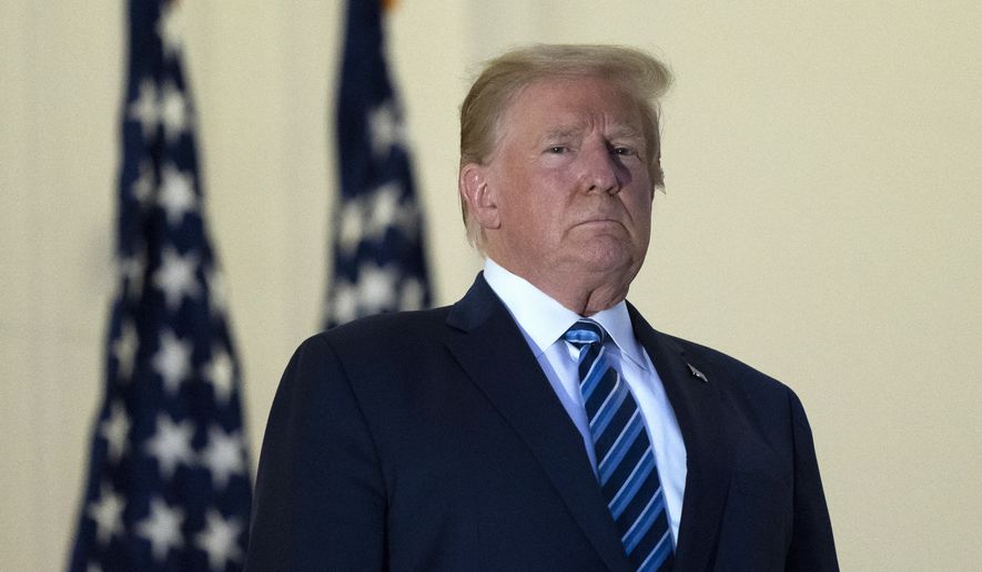 President Donald Trump stands on the Blue Room Balcony upon returning to the White House Monday, Oct. 5, 2020, in Washington, after leaving Walter Reed National Military Medical Center, in Bethesda, Md. Trump announced he tested positive for COVID-19 on Oct. 2. (AP Photo/Alex Brandon)