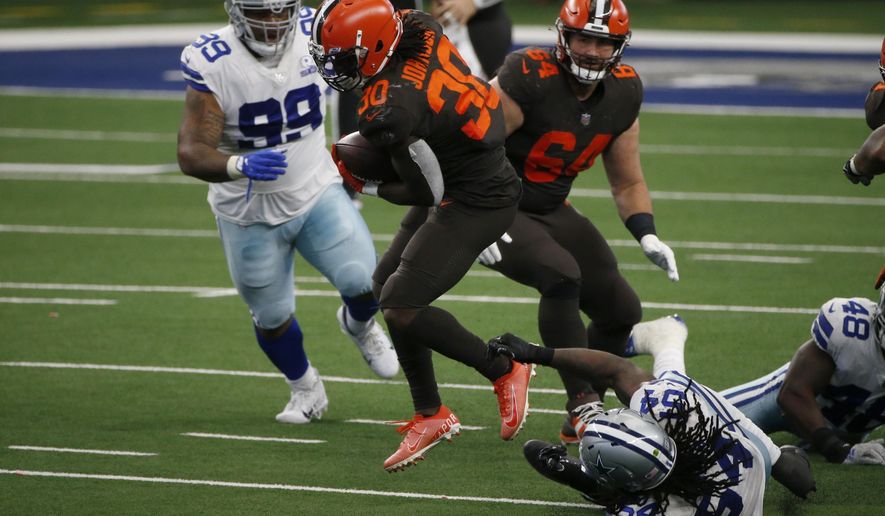 Cleveland Browns running back D'Ernest Johnson (30) attempts to break the grasp of Dallas Cowboys linebacker Jaylon Smith (54) after running the ball for a first down in the second half of an NFL football game in Arlington, Texas, Sunday, Oct. 4, 2020. The Cowboys' Antwaun Woods (99) and the Browns' JC Tretter (64) look on during the play. (AP Photo/Michael Ainsworth)