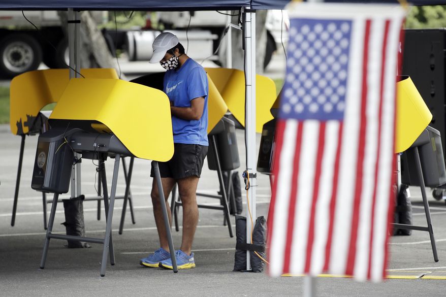 FILE - In this May 12, 2020, file photo, Arjan Walia votes during a special election in Santa Clarita, Calif. The Nov. 3 election will test California's commitment to voting by mail as the nation's most populous state will offer fewer in-person polling places hoping it will convince more people to cast ballots from the safety of their mailboxes during a pandemic. If it doesn't work, the state could see long lines and frustrated voters on Election Day compounded by coronavirus protocols that will make voting in person slower in a year expected to draw a big turnout. (AP Photo/Marcio Jose Sanchez, File)