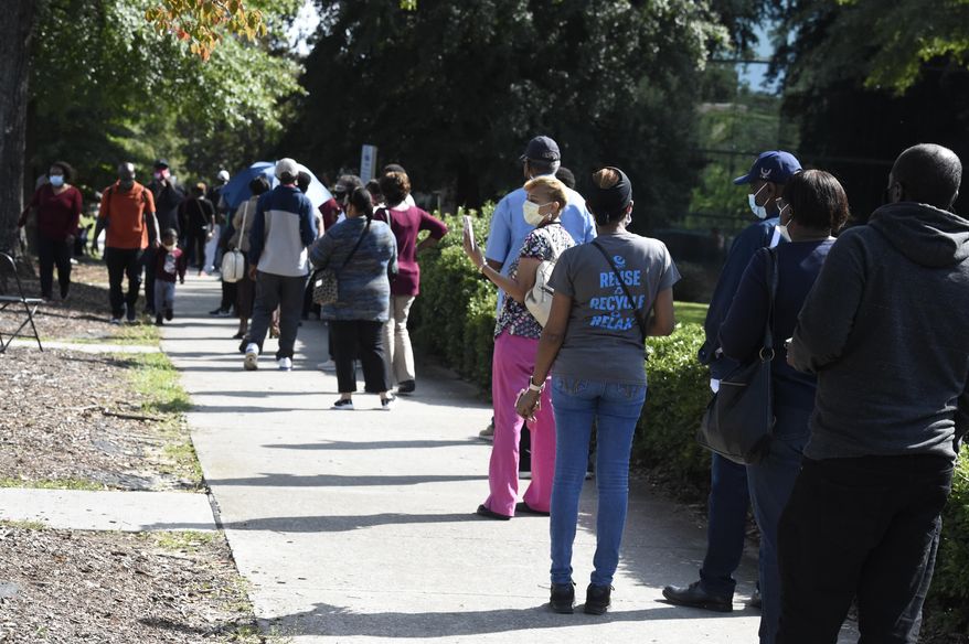 Voters wait in line outside the Richland County election office on the first day of in-person absentee voting in South Carolina on Monday, Oct. 5, 2020, in Columbia, S.C. A number of counties have polling places where people can vote almost like they would in person on Election Day, instead of having to mail in their absentee ballot. (AP Photo/Meg Kinnard)