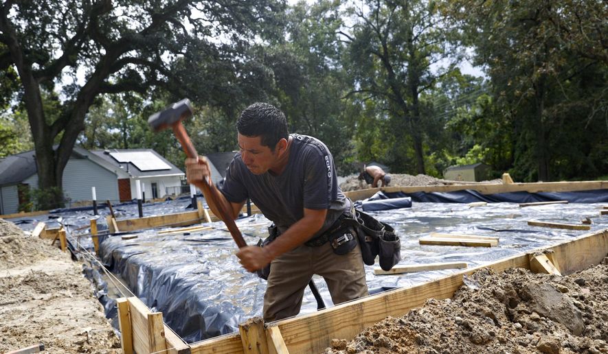 In this Friday, Sept. 25, 2020, photo, Erik Garcia uses a sledgehammer on the foundation of a new house in Hanahan, S.C. The city of Hanahan has issued almost as many demolition permits since January as in the past three years combined. (Andrew J. Whitaker/The Post And Courier via AP)
