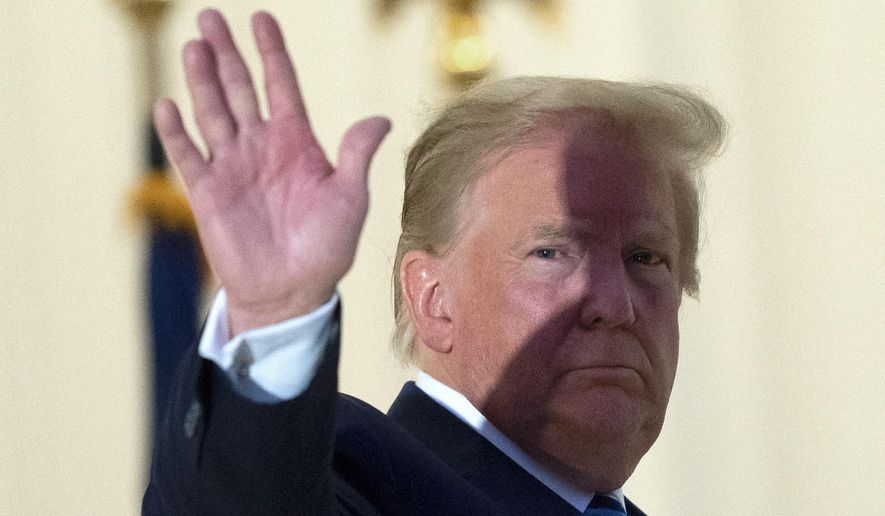 President Donald Trump waves from the Blue Room Balcony upon returning to the White House Monday, Oct. 5, 2020, in Washington, after leaving Walter Reed National Military Medical Center, in Bethesda, Md. Trump announced he tested positive for COVID-19 on Oct. 2. (AP Photo/Alex Brandon)