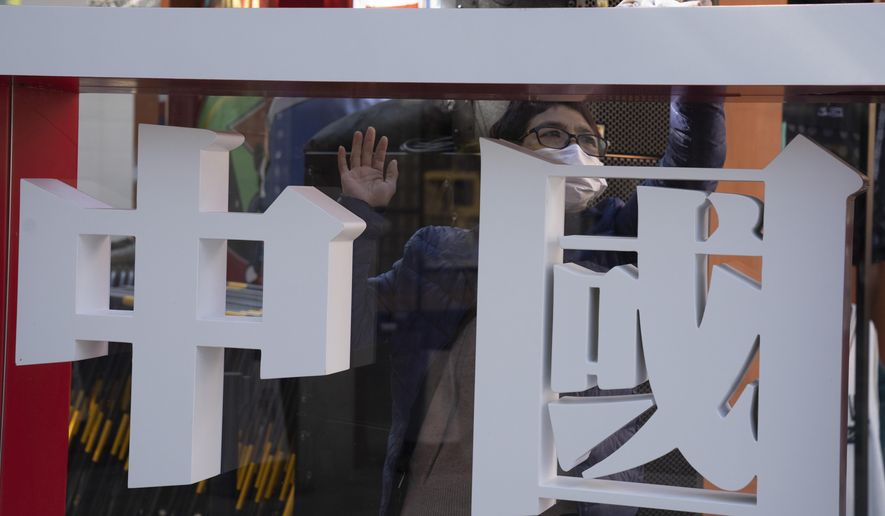 A worker cleans the panel with the words "China" written on it during a Chinese sporting goods brand promotion event in Beijing on Sunday, Oct. 4, 2020. Negative perceptions of China have increased sharply in many of the world's advanced economies, especially in Australia and the U.K., a new survey from the Pew Research Center showed Tuesday, Oct. 6, 2020. (AP Photo/Ng Han Guan)