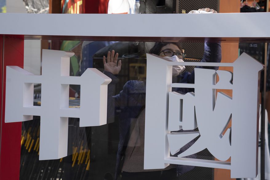 A worker cleans the panel with the words "China" written on it during a Chinese sporting goods brand promotion event in Beijing on Sunday, Oct. 4, 2020. Negative perceptions of China have increased sharply in many of the world's advanced economies, especially in Australia and the U.K., a new survey from the Pew Research Center showed Tuesday, Oct. 6, 2020. (AP Photo/Ng Han Guan)