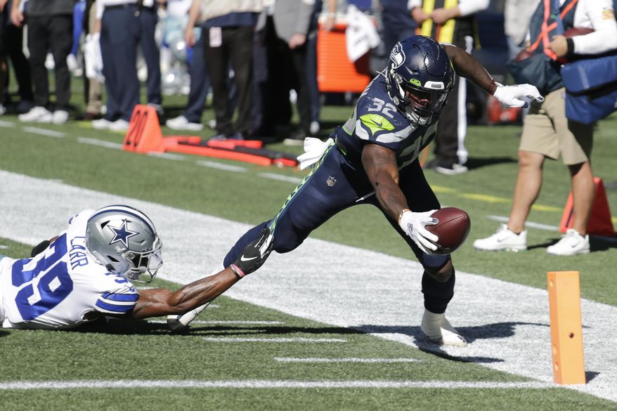 Seattle Seahawks running back Chris Carson (32) dives near the end zone as Dallas Cowboys cornerback Brandon Carr (39) attempts the tackle during the first half of an NFL football game, Sunday, Sept. 27, 2020, in Seattle. The Seahawks won 38-31. (AP Photo/John Froschauer)