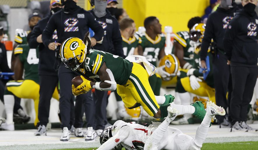 Green Bay Packers' Jamaal Williams (30) is tackled by Atlanta Falcons' Damontae Kazee (27) during the first half of an NFL football game, Monday, Oct. 5, 2020, in Green Bay, Wis. (AP Photo/Tom Lynn)