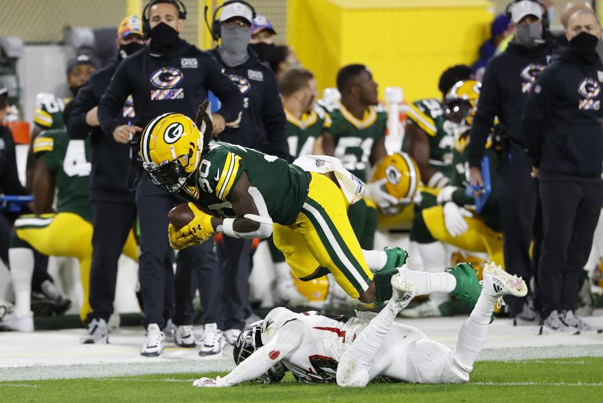 Green Bay Packers' Jamaal Williams (30) is tackled by Atlanta Falcons' Damontae Kazee (27) during the first half of an NFL football game, Monday, Oct. 5, 2020, in Green Bay, Wis. (AP Photo/Tom Lynn)