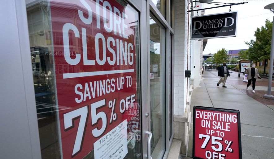 In this Wednesday, Sept. 2, 2020, file photo, passers-by walk past a business storefront with store closing and sale signs in Dedham, Mass. U.S. employers advertised for slightly fewer jobs in August while their hiring ticked up modestly. The Labor Department said Tuesday, Oct. 6, 2020,  that the number of U.S. job postings on the last day of August dipped to 6.49 million, down from 6.70 million July. (AP Photo/Steven Senne, File)