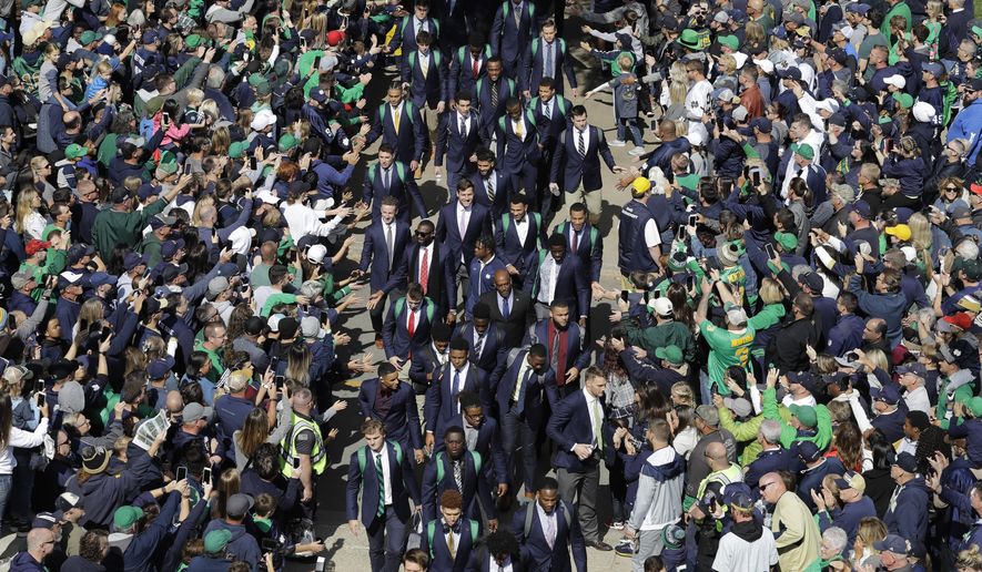 FILE - In this Oct. 5, 2019, file photo, Notre Dame players greet fans as they enter the stadium before an NCAA college football game against Bowling Green, in South Bend, Ind. In a quirk this season, No. 5 Notre Dame enjoys a greater home-field advantage than most of its opponents: As of now, the Fighting Irish are slated to play in front of only one crowd bigger than their own, which is limited to about 10,000 people because of the pandemic. (AP Photo/Darron Cummings, File)