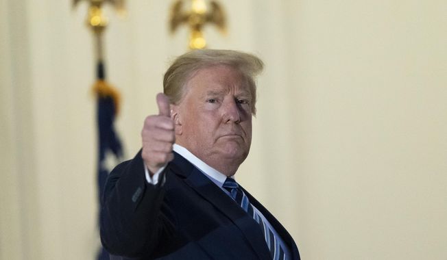 President Donald Trump gives thumbs up from the Blue Room Balcony upon returning to the White House Monday, Oct. 5, 2020, in Washington, after leaving Walter Reed National Military Medical Center, in Bethesda, Md. Trump announced he tested positive for COVID-19 on Oct. 2. (AP Photo/Alex Brandon)