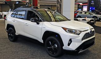 FILE - This Feb. 13, 2020 photo shows a 2020 Toyota RAV4 Hybrid on display at the 2020 Pittsburgh International Auto Show in Pittsburgh.  The Toyota RAV4 Hybrid and Honda CR-V Hybrid are similar in fuel economy, power and practicality according to Edmunds. Each is a smart buy for a fuel-efficient SUV. (AP Photo/Gene J. Puskar, File).