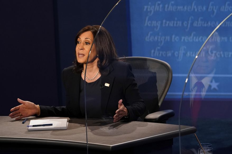 Vice President Mike Pence is reflected in the plexiglass barrier as Democratic vice presidential candidate Sen. Kamala Harris, D-Calif., answers a question during the vice presidential debate Wednesday, Oct. 7, 2020, at Kingsbury Hall on the campus of the University of Utah in Salt Lake City. (AP Photo/Morry Gash, Pool)