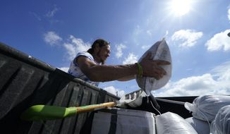 fill sandbags to protect their home in anticipation of Hurricane Delta, expected to arrive along the Gulf Coast later this week, in Houma, La., Wednesday, Oct. 7, 2020. (AP Photo/Gerald Herbert)