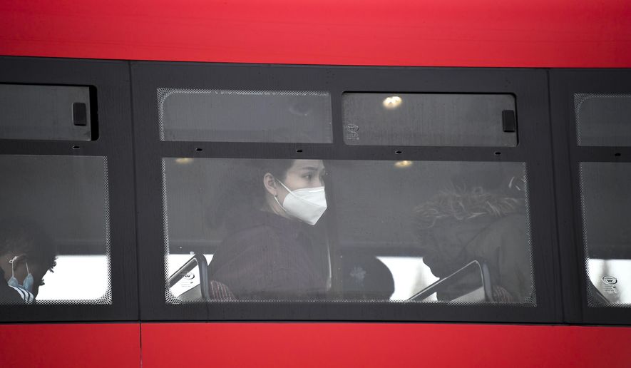 A woman wears a face mask as she sits on a bus, in London, Wednesday, Oct. 7, 2020. Like other countries in Europe, the U.K. has seen rising coronavirus infections over the past few weeks, which has prompted the government to announce a series of restrictions, both nationally and locally, to keep a lid on infections. (AP Photo/Alberto Pezzali)