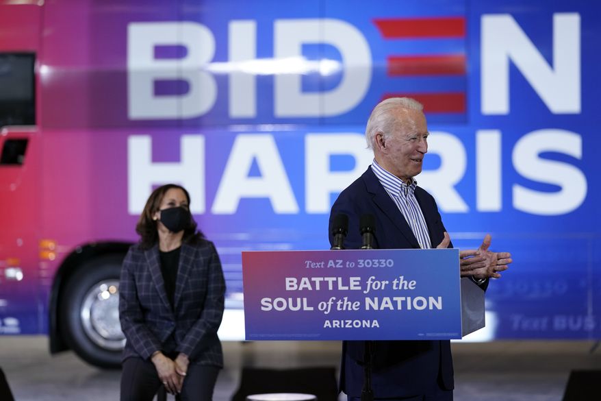 Democratic presidential candidate former Vice President Joe Biden speaks as Democratic vice presidential candidate Sen. Kamala Harris, D-Calif., listens as they visit the Carpenters Local Union 1912 in Phoenix, Thursday, Oct. 8, 2020, to kick off a small business bus tour. (AP Photo/Carolyn Kaster)