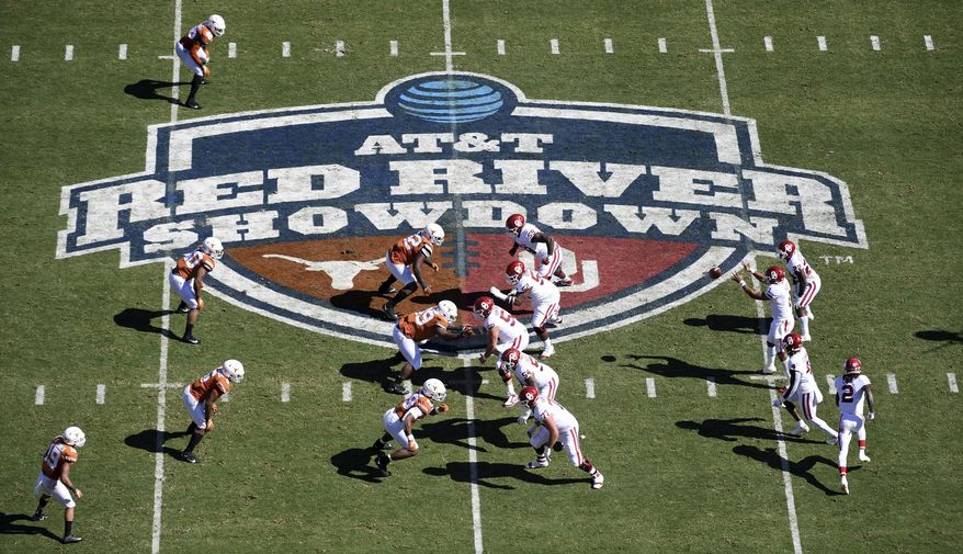 FILE - In this Oct. 12, 2019, file photo, Oklahoma, right, runs a play against Texas in the first half of an NCAA college football game at the Cotton Bowl in Dallas. No. 22 Texas vs. Oklahoma, at Cotton Bowl Stadium, Dallas. There is no State Fair of Texas this year because of the pandemic and both teams are coming off a loss, but this is still the Red River rivalry, (AP Photo/Jeffrey McWhorter, File)