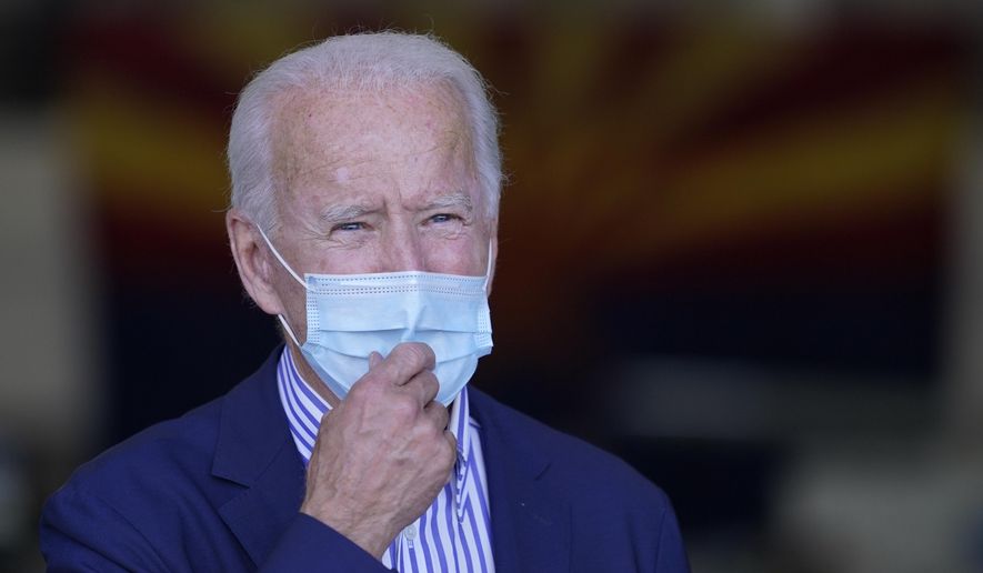 With the Arizona state flag in the background, Democratic presidential candidate former Vice President Joe Biden speaks to members of the media before leaving Phoenix Sky Harbor International Airport, in Phoenix, Thursday, Oct. 8, 2020. (AP Photo/Carolyn Kaster)