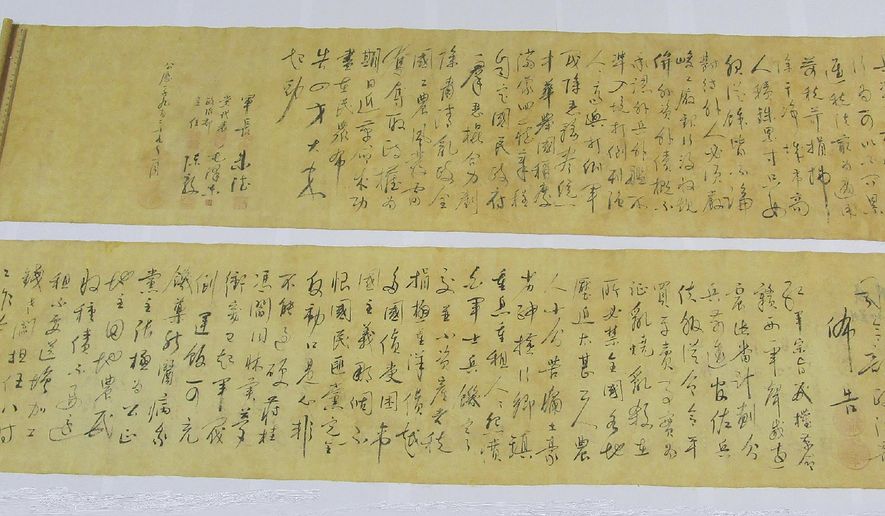In this photo provided by Hong Kong Police Force, two pieces of a calligraphy scroll by former Chinese leader Mao Zedong estimated to be worth about $296.7 million are displayed in Hong Kong, Tuesday, Oct. 6, 2020. The South China Morning Post newspaper quoting an unnamed police source who reported that the calligraphy scroll was cut in half by a buyer who had purchased it for 500 Hong Kong dollars ($64.50) and had believed the scroll to be counterfeit. (Hong Kong Police Force via AP)