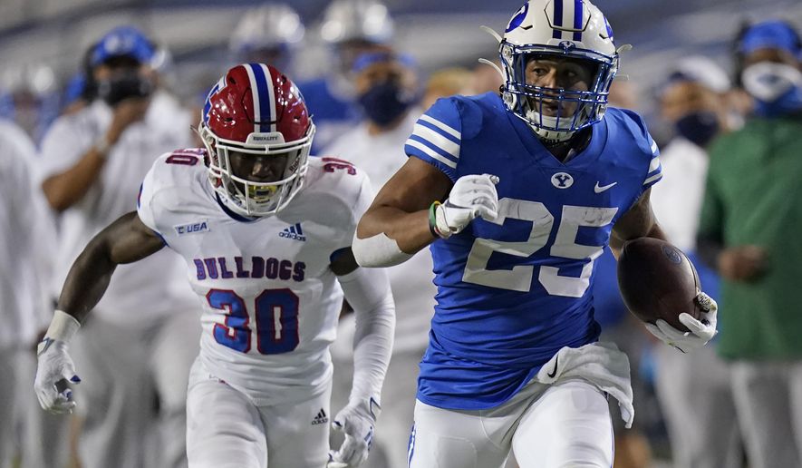 BYU running back Tyler Allgeier (25) carries the ball as Louisiana Tech defensive back Cedric Woods (30) pursues during the second half of an NCAA college football game Friday, Oct. 2, 2020, in Provo, Utah. (AP Photo/Rick Bowmer, Pool)