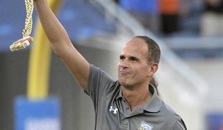 In this Saturday, Aug. 24, 2019, file photo, Marcus Lemonis waves to fans after participating in the coin toss before an NCAA college football game between Florida and Miami, in Orlando, Fla. (AP Photo/Phelan M. Ebenhack, File)