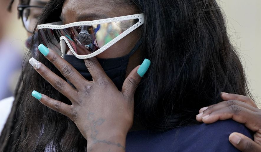 Deja Stallings wipes away tears during a news conference outside city hall Thursday, Oct. 8, 2020, in Kansas City, Mo. Protesters have occupied the lawn and plaza in front of city hall more than a week demanding the resignation of police chief Rick Smith and the officer who knelt on Stallings' back while arresting the pregnant woman last week. (AP Photo/Charlie Riedel)