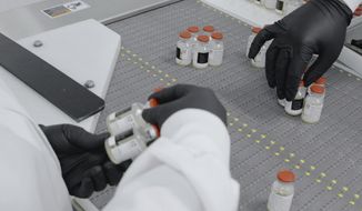 In this undated image from video provided by Regeneron Pharmaceuticals on Friday, Oct. 2, 2020, vials are inspected at the company&#39;s facilities in New York state, for efforts on an experimental coronavirus antibody drug. Antibodies are proteins the body makes when an infection occurs; they attach to a virus and help the immune system eliminate it. (Regeneron via AP)