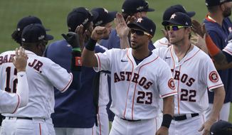 Houston Astros manager Dusty Baker Jr., left, celebrates with Michael Brantley (23), Josh Reddick (22) and others after the Astros defeated the Oakland Athletics in Game 4 of a baseball American League Division Series in Los Angeles, Thursday, Oct. 8, 2020. (AP Photo/Ashley Landis)