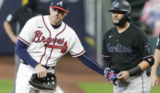 Atlanta Braves first baseman Freddie Freeman, left, taps Miami Marlins&#x27; Miguel Rojas, right, on the hip after Rojas was hit by a pitch during the eighth inning in Game 1 of a baseball National League Division Series Tuesday, Oct. 6, 2020, in Houston. The Braves won 9-5. (AP Photo/Michael Wyke)