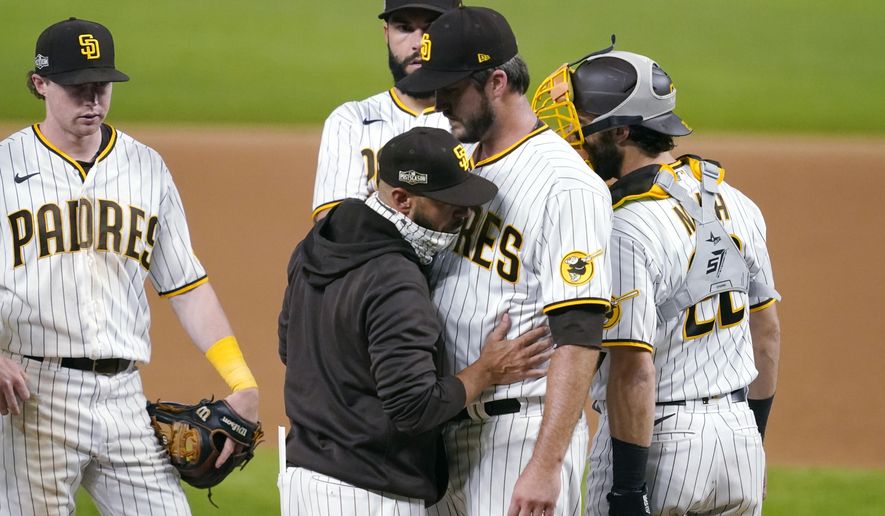 San Diego Padres manager Jayce Tingler, in jacket, takes pitcher Drew Pomeranz out of the game against the Los Angeles Dodgers during the eighth inning in Game 3 of a baseball National League Division Series Thursday, Oct. 8, 2020, in Arlington, Texas. (AP Photo/Tony Gutierrez)