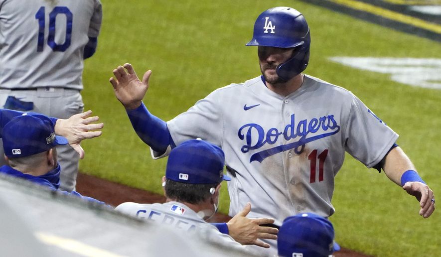 Los Angeles Dodgers&#x27; A.J. Pollock (11) is congratulated after scoring on a sacrifice fly by Mookie Betts against the San Diego Padres during the fifth inning in Game 3 of a baseball National League Division Series Thursday, Oct. 8, 2020, in Arlington, Texas. (AP Photo/Sue Ogrocki)